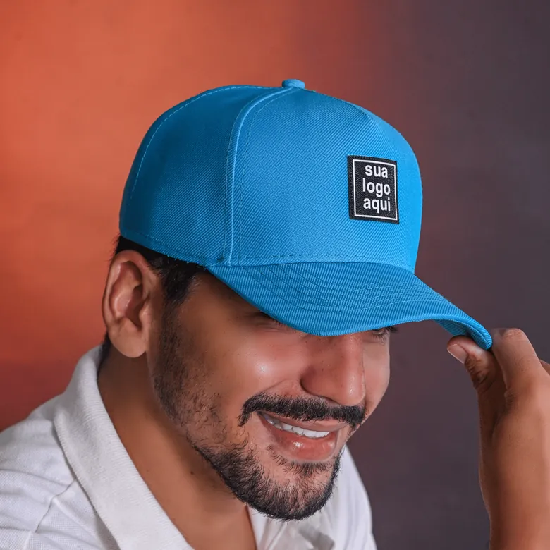 Homem usando boné snapback azul com patch personalizado "sua logo aqui"