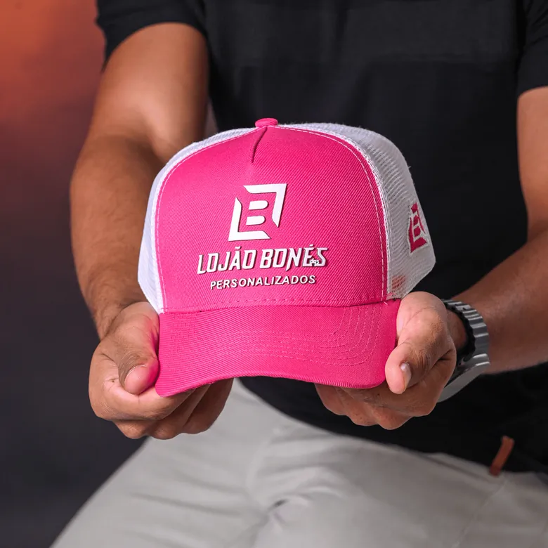 Boné trucker rosa e branco com logo bordado do Lojão dos Bonés nas mãos